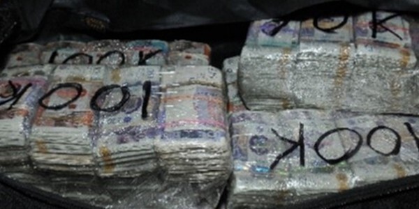 Bundles of notes wrapped in plastic with each marked 'one hundred thousand'.