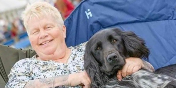Susan Foreman smiling and sitting with a dog on her lap