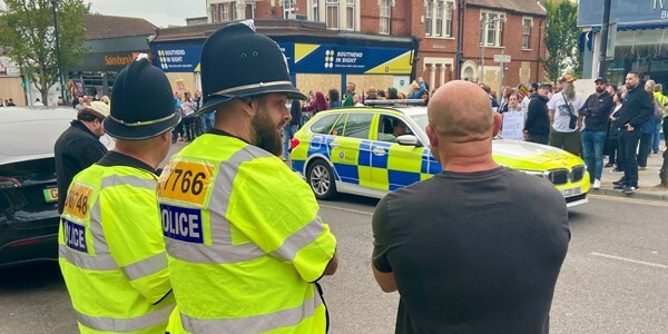 Two police officers chatting with a member of the public on Hamlet Court Road in Southend with a small group behind