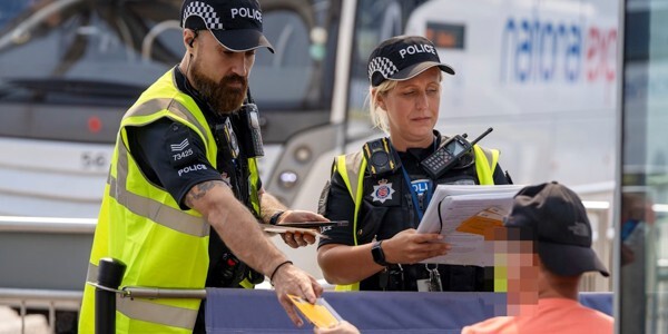 Officers check the details of a man who'd come to their attention at the bus station.