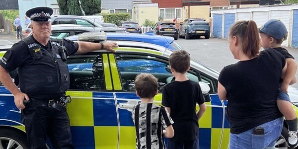 Officer and a family next to a police car