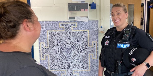 Tendring District Commander Chief Inspector Ella Latham talking to a member of the public next to a mosaic