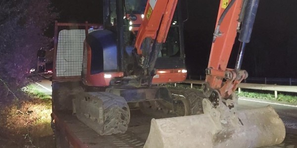 Digger at the side of the road at night