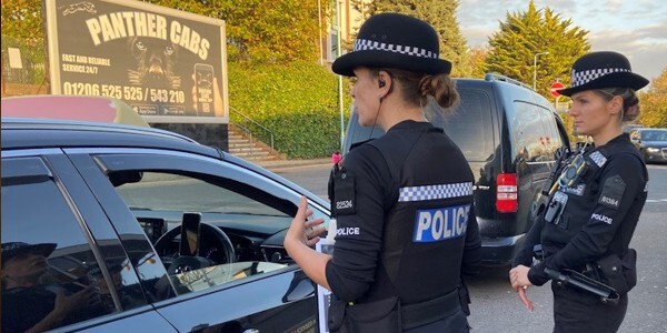 Two officers discussing the campaign with the driver of a car