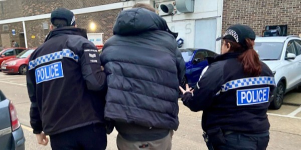 Two police officers arresting a man