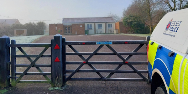 Police Vehicle parked outside the gate of a village hall
