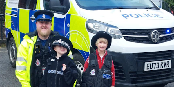 PCSO Stewart with children wearing police hats