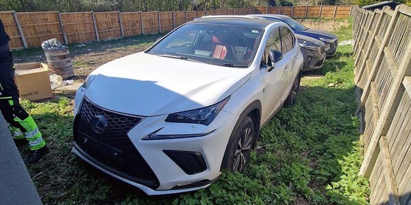 White car with several others behind it - in a back garden