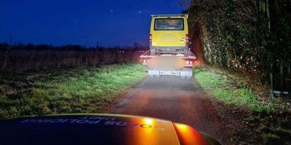 Yellow van on a lorry in front of an Essex Police Roads Police Unit vehicle
