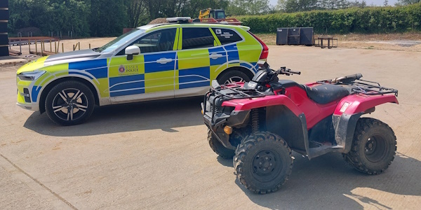 A Police Vehicle parked alongside a Red Quad Bike