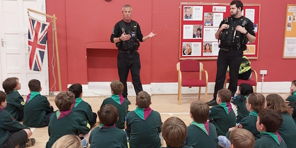 Police Officers speaking to a group of children who are sat on the floor 