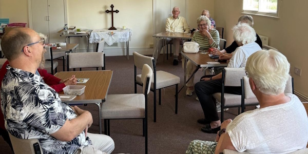 Residents sitting in a circle listening to a talk