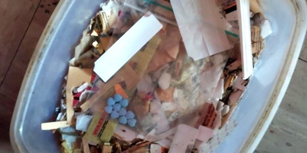 drugs, tablets and packets in a plastic tub