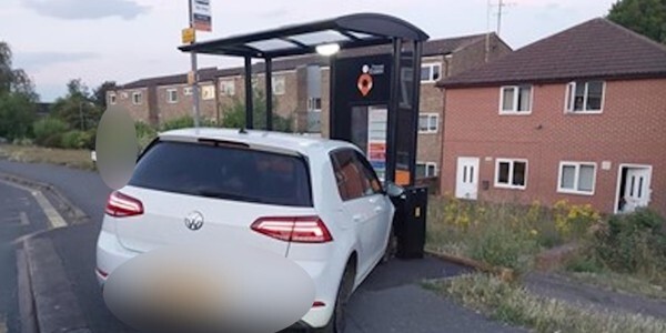VW car abandoned in front of a bus stop