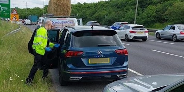 Officer at the roadside dealing with a blue car