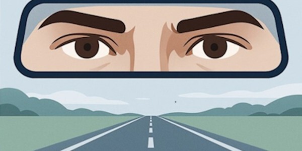 Graphic drawing of eyes in a rear view mirror with the road ahead