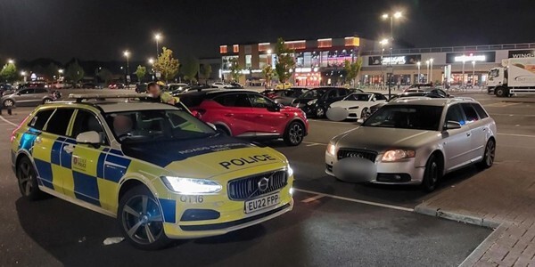 Police car with other cars in a car park at night