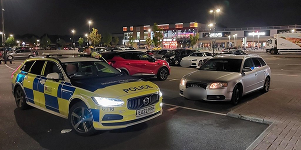 Marked police car on patrol in car park