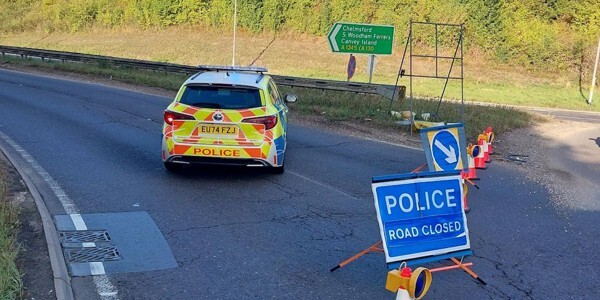 Police patrol car at a cordon on the A130 with a 'road closed' sign