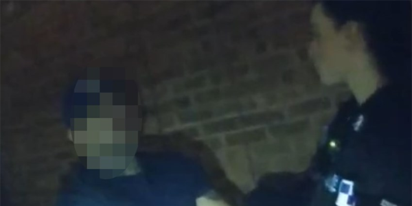 Uniformed police officer arresting a person