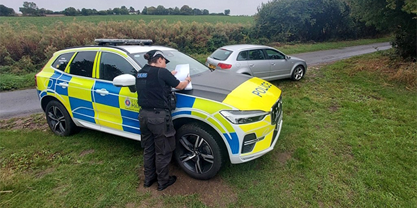 Rural Engagement Team officer checking car details on rural road