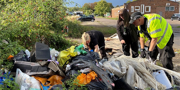 Rural Engagement Team officer looking through fly-tipped waste