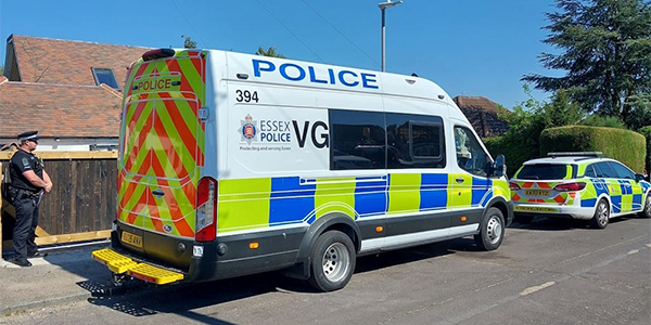 Police van and police car parked outside property