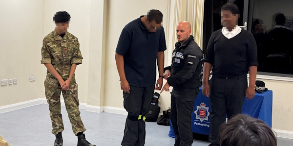 uniformed officer demonstrating the use of limb restraints with army cadets