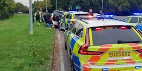 Arrests and checks on a stopped car with police car in the foreground