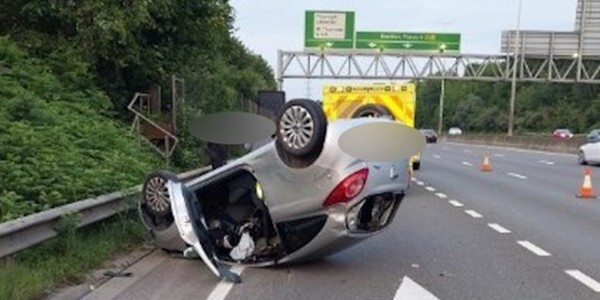 Silver Ka car on it's roof at the side of the road