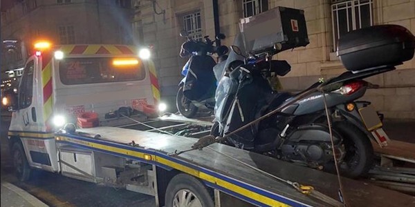 Mopeds on a transporter lorry at night