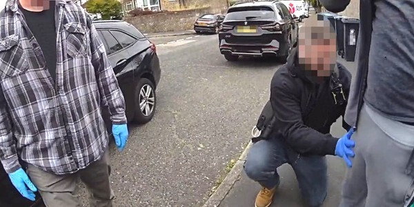 Daniel Ikumelo being searched before his arrest