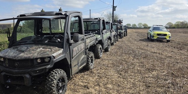 Three stolen farm vehicles in a field next to a police car