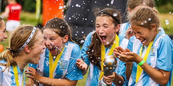 Girls football team celebrates community goals tournament win
