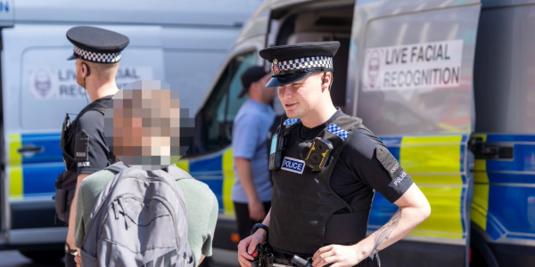 Police officer speaking to member of the public about LFR vans