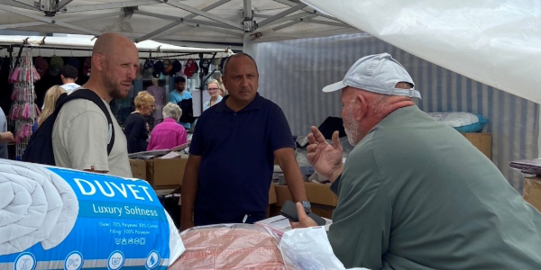 Business crime officers speak to a market stall holder