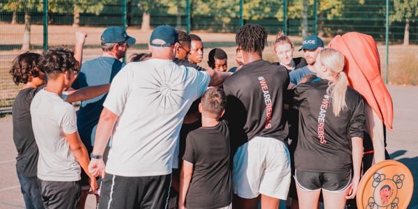 Officers and Essex Rebels players with children on a basketball court
