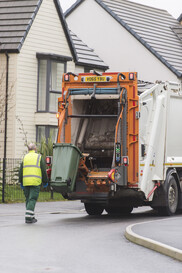 Green bin being loaded into a truck 