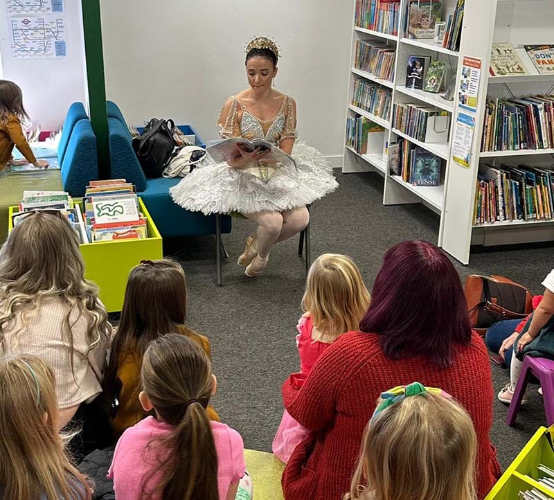 Ballet dancer reading to children in central library