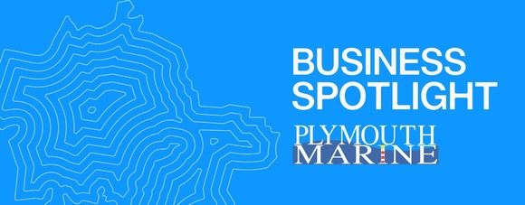 A bright blue graphic with contour map lines on the left side and the words "BUSINESS SPOTLIGHT" in large white text to the right.