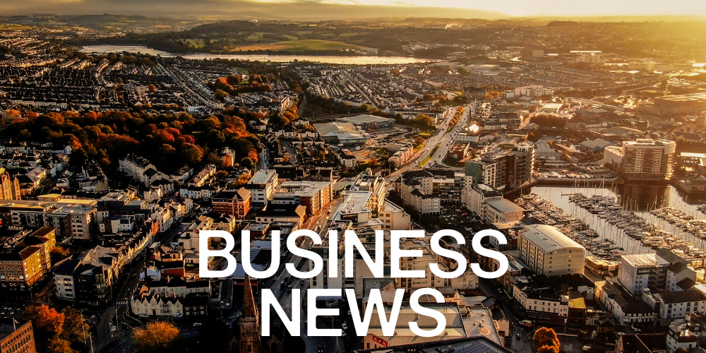 Aerial view of a city at sunset with the words “Business News” in large white text across the foreground.