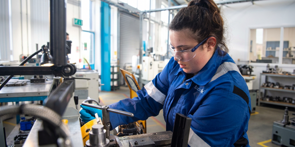 Engineer in blue workwear operating machinery in a workshop