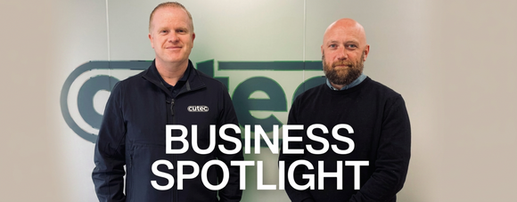 Two people standing in front of a wall with the Cutec logo and the words “Business Spotlight.”