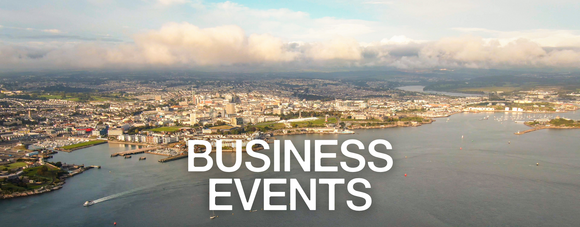 Aerial view of a coastal city with large white text reading “Business Events” over the water.