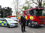 Roger Hirst in front of a police car and fire engine