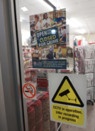Shop window with a 'Open for business closed for crime' poster 