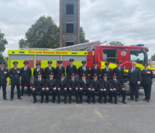 New firefighters lined up in front of a fire engine