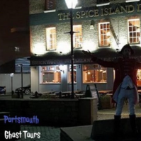 Night time photo of an actor dressed in historical costume standing in front of The Spice Island Inn