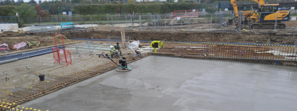 concrete being buffered in a pool construction