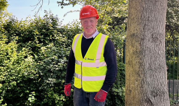 Man in PPE stood by a tree